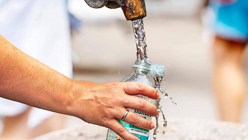 Eine Frau f&uuml;llt Wasserflasche mit frischem Trinkwasser am Marienplatz.