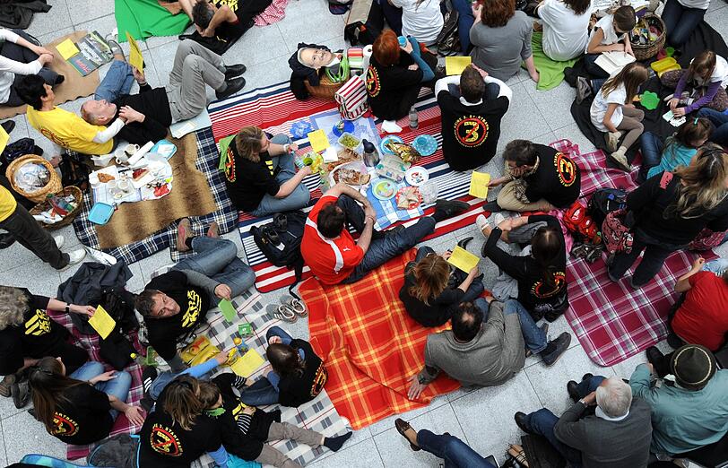 Gegen Fluglärm demonstrierende Demonstranten picknicken am Samstag (24.03.12) am Flughafen Franz-Josef-Strauss in einem Teil der Abflughalle des Terminal 2.