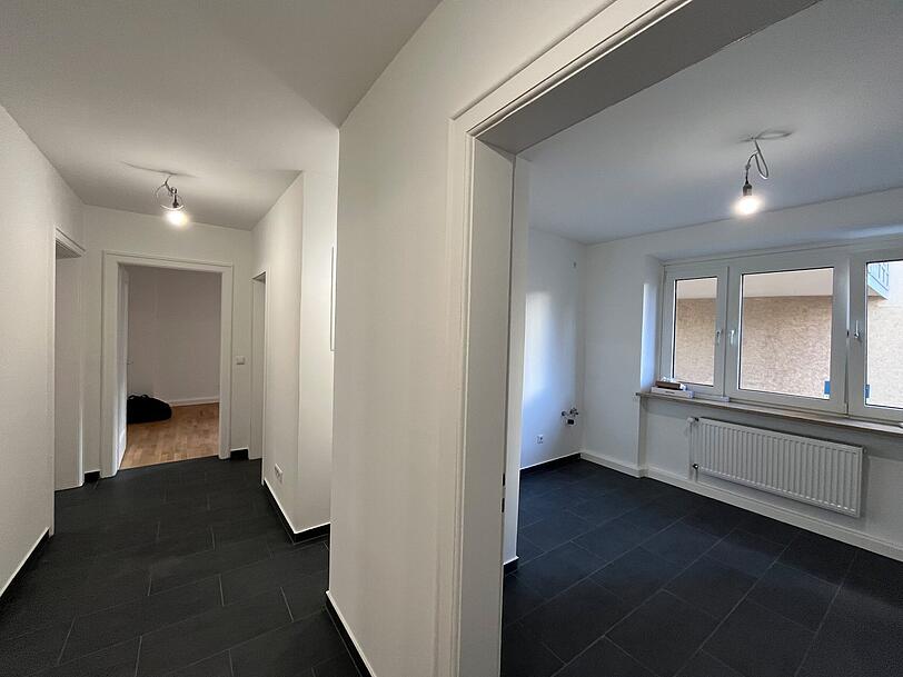 Von einem schmalen Flur gehen die vier Zimmer ab. Der Raum rechts wird die Küche. Geschirrspüler und Co. baut der Vermieter noch ein.