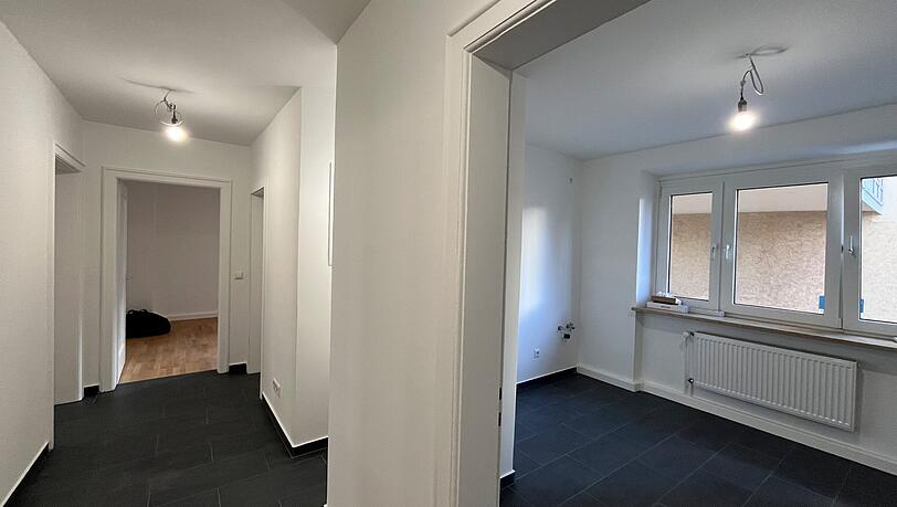 Von einem schmalen Flur gehen die vier Zimmer ab. Der Raum rechts wird die Küche. Geschirrspüler und Co. baut der Vermieter noch ein.