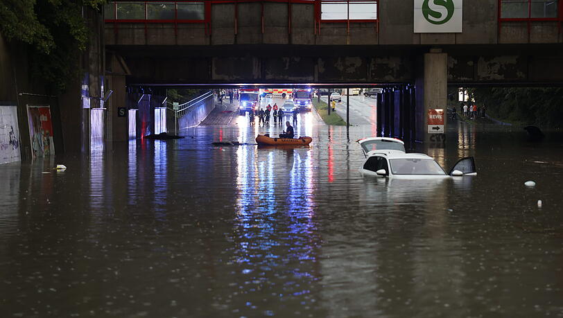 Heftige Bilder aus Nürnberg: Einsatzkräfte der Feuerwehr können nur noch mit einem Schlauchboot zu den Autos in einer überschwemmten Unterführung gelangen.