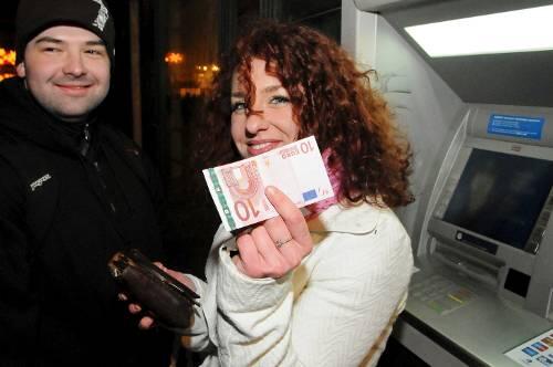 Stolz zeigt diese Frau in Bratislava um kurz nach Mitternacht ihre frisch gezogenen Euro-Scheine.