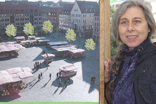 Der Hauptmarkt soll grüner werden: Ingrid Treutter vom Bund Naturschutz vor einer Fotomontage mit den Bäumen im Zentrum.