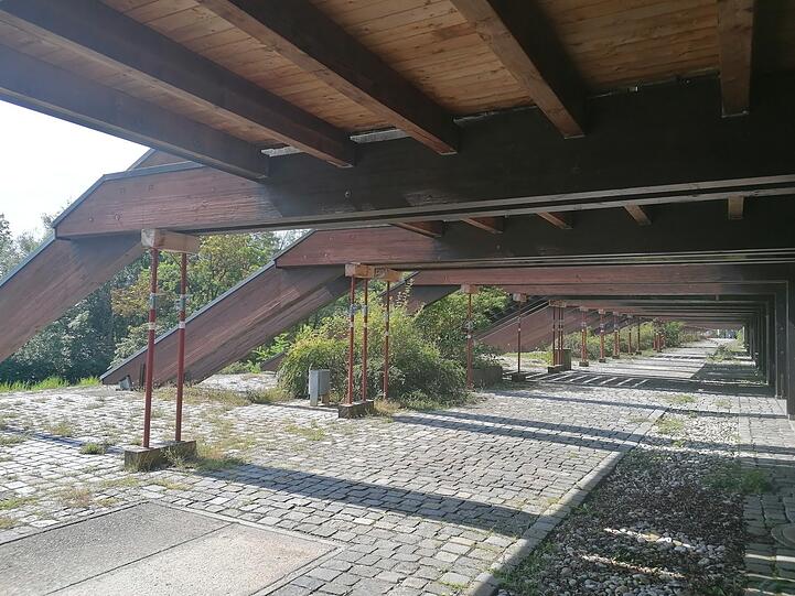 Hinten halten Stangen die Tribüne.