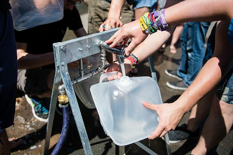 Wegen der großen Hitze füllen Besucher vor dem offiziellen Beginn des Musikfestivals "Rock im Park") ihre Kanister mit Trinkwasser. Das Festival dauert bis zum 7. Juni.