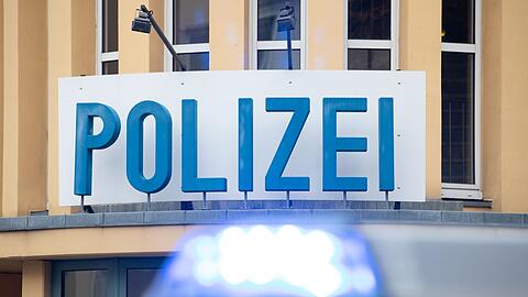 Ein Einsatzwagen der Polizei steht vor einer Dienststelle.