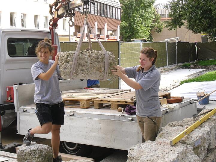 Geschichte am Haken: Die Steinmetzinnen Judith Hartung (l.) und Vanessa Goldbrunner mit einem Stück der Zwingermauer.