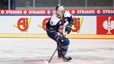 Zach Redmond vom EHC München spielt den Puck.