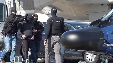 Ein mutmaßliches Mitglied der Terrormiliz IS wird auf dem Flughafen Hamburg zu einem Hubschrauber der Bundespolizei gebracht.