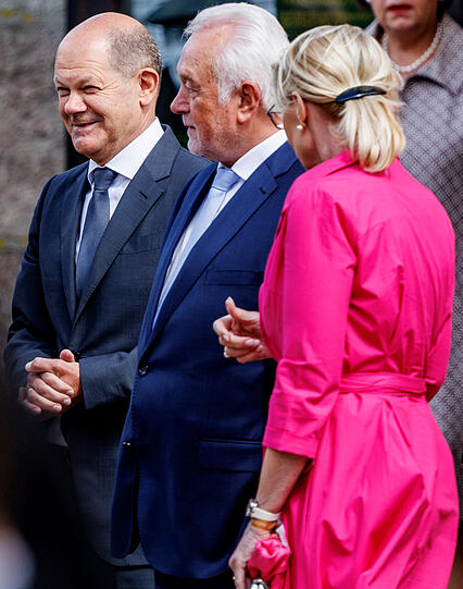 Bundeskanzler Olaf Scholz (SPD, l) steht mit Wolfgang Kubicki (FDP), Bundestagsvizepräsident, und seiner Frau Annette Marberth-Kubicki an der Kirche.