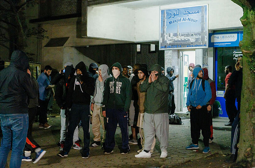 Maskierte Jugendliche stehen vor der Al-Nour Moschee in Hamburg.