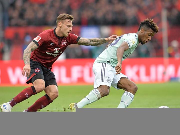 Der Nürnberger Robert Bauer (l) und der Münchner Kingsley Coman im Kampf um den Ball. Foto: Timm Schamberger