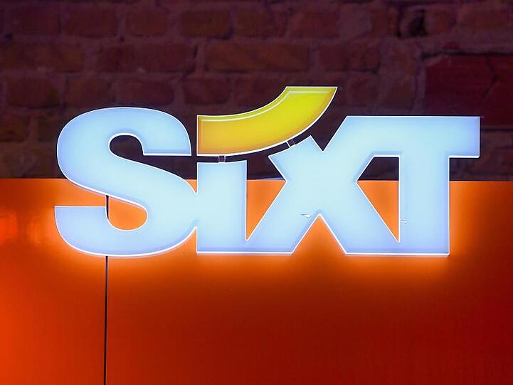 Das Logo des Autovermieters Sixt hängt an einer Wand. Foto: Jens Kalaene