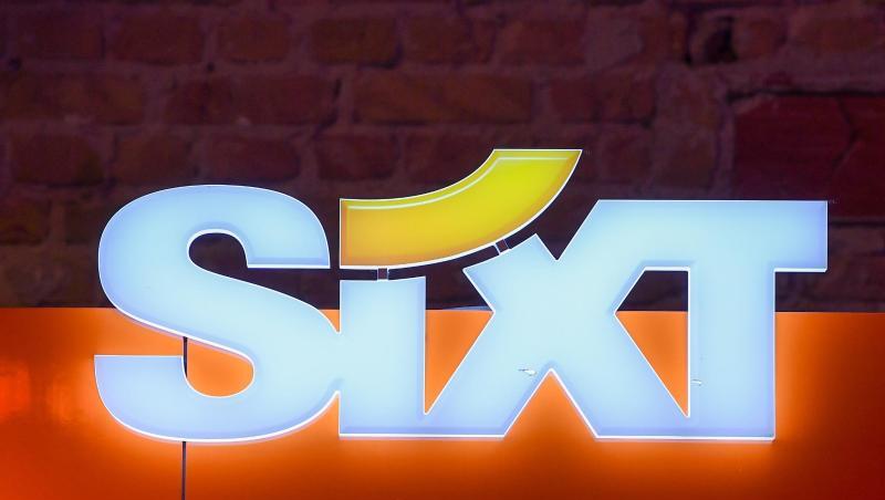 Das Logo des Autovermieters Sixt hängt an einer Wand. Foto: Jens Kalaene Das Logo des Autovermieters Sixt hängt an einer Wand. Foto: Jens Kalaene