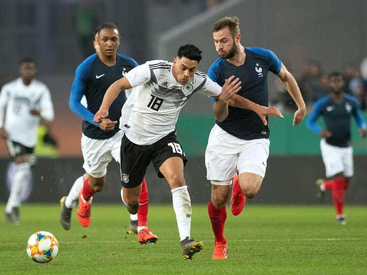 DFB-Akteur Nadiem Amiri (M) versucht dem Franzosen Lucas Tousart zu enteilen.