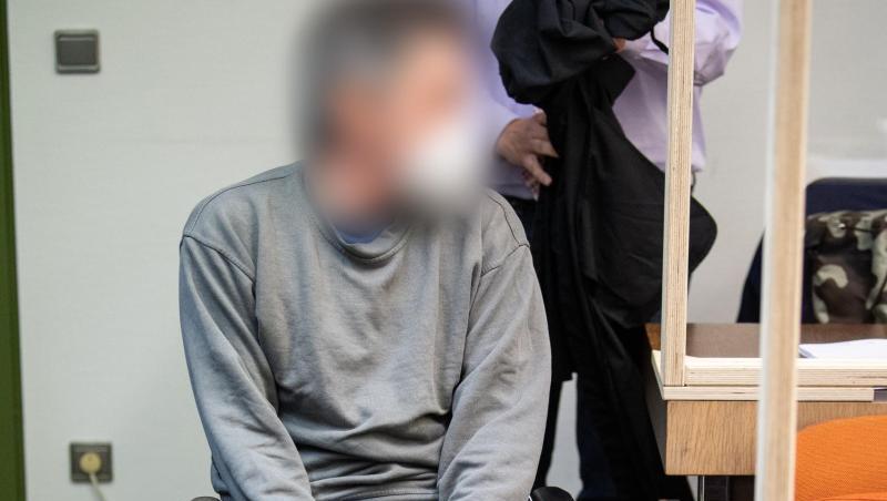 Ein wegen Mordes Angeklagter, der seinen Transporter in den Gegenverkehr gesteuert und so einen Autofahrer getötet haben soll, sitzt zum Prozessauftakt im Rollstuhl in einem Gerichtssaal vom Landesgericht München II.