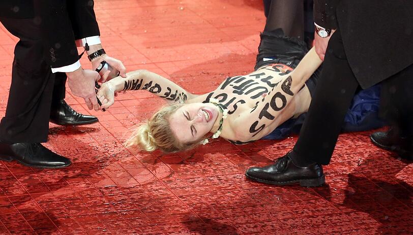 Die Aktivistinnen der ukrainischen Frauenrechtsorganisation Femen entblößten ihren Oberkörper am Rande des Roten Teppichs, um gegen die Beschneidung von Frauen zu demonstrieren.
