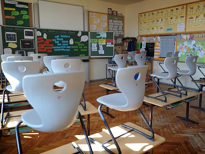 Stühle stehen in einer Grundschule auf den Tischen. Foto: David Ebener/dpa/Archivbild