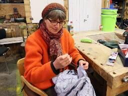 Britta-Marei Lanzenberger ist gelernte Schneiderin. Im Repair Café zeigt sie Interessierten, wie sich lose Knöpfe wieder anbringen lassen.