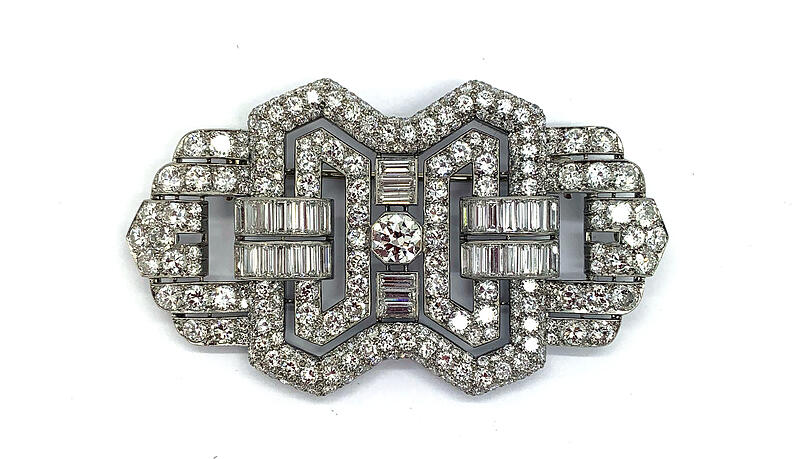 Art-déco-Diamantbrosche um 1920/1930 mit insgesamt 21,6 ct, Platin. Mittelstein: 1 Diamant von 1,2 ct, 34 Baguettes (zusammen 6,4 ct) sowie 252 Brillanten (zusammen 14,0 ct). (Kunsthaus Nüdling, Stand 25) Art-déco-Diamantbrosche um 1920/1930 mit insgesamt 21,6 ct, Platin. Mittelstein: 1 Diamant von 1,2 ct, 34 Baguettes (zusammen 6,4 ct) sowie 252 Brillanten (zusammen 14,0 ct). (Kunsthaus Nüdling, Stand 25)
