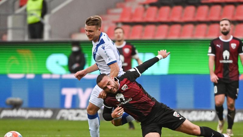 Marco Thiede von Karlsruhe (l) und Rico Preißinger von Ingolstadt kämpfen um den Ball.
