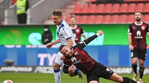 Marco Thiede von Karlsruhe (l) und Rico Preißinger von Ingolstadt kämpfen um den Ball.