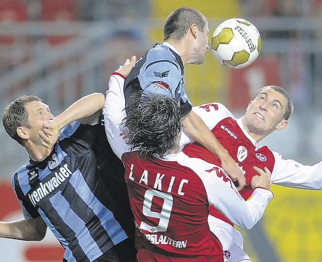 Kämpferisch wertvoll: Die Löwen Gregg Berhalter (l) und Mate Ghvinianidze (hinten) im Duell mit Lauterns Erik Jendrisek (r) und Srdjan Lakic (2.v.r). Foto: dpa