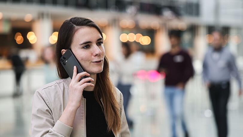 Die f&uuml;r KI zust&auml;ndige Telekom-Mitarbeiterin Lena Drubel f&uuml;hrt bei einer Testvorf&uuml;hrung des KI-Assistenten ein Handytelefonat.