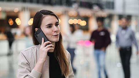 Die f&uuml;r KI zust&auml;ndige Telekom-Mitarbeiterin Lena Drubel f&uuml;hrt bei einer Testvorf&uuml;hrung des KI-Assistenten ein Handytelefonat.