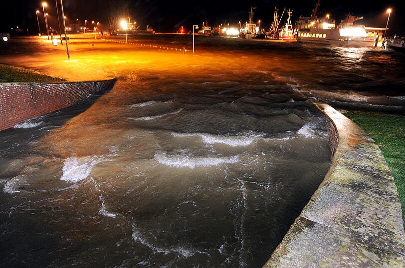 Mit Macht läuft die Nordsee während der zweiten Sturmflut des Orkans Xaver am frühen Morgen des 06.12.2012 gegen den geschlossenen Deichschart am Hafen von Bensersiel (Niedersachsen).