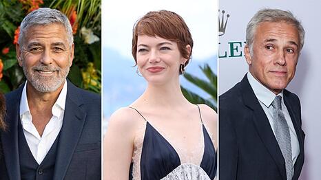 George Clooney (l.), Emma Stone und Christoph Waltz befinden sich 2025 allesamt im Wettbewerb um den Goldenen Löwen von Venedig.