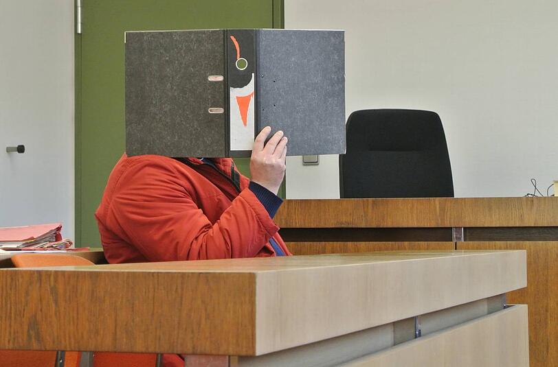 Mit einem Aktenordner vor dem Gesicht sitzt der Windel-Fetischist Thomas H. (28) im Münchner Landgerichtssaal.