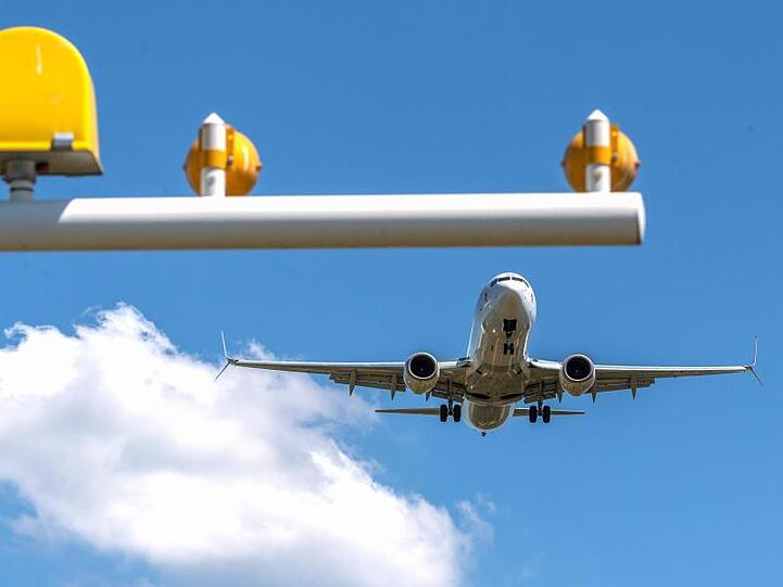 Ein Flugzeug im Landeanflug auf einen Flughafen.