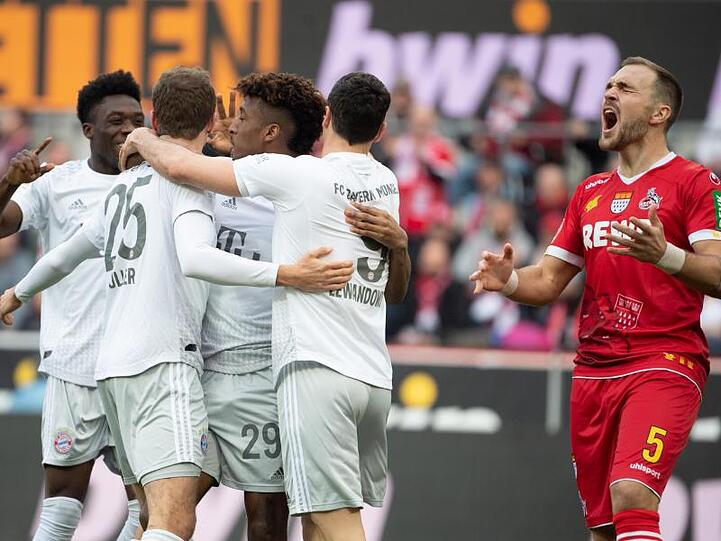 Bayerns Alaba (l-r), Müller, Coman und Lewandowski feiern das 2:0. Kölns Czichos (r) schreit und ärgert sich.