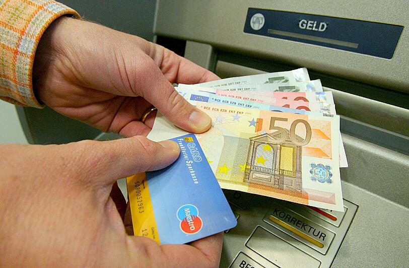 Ein Kunde hebt Geld mit seiner Girokarte ab. Manchmal lohnt es sich, für sein Girokonto ein bisschen Geld abzuzwicken und dafür andere Vorteile zu kassieren.
