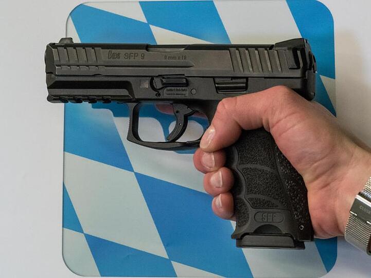 Eine Polizistin hält die zukünftige Dienstwaffe in der Hand. Foto: Peter Kneffel/dpa/Archivbild