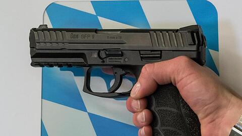 Eine Polizistin hält die zukünftige Dienstwaffe in der Hand. Foto: Peter Kneffel/dpa/Archivbild