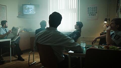 In der Polizeikaserne läuft die Geiselnahme im Fernsehen. Es ist das erste Mal, dass es Live-Übertragungen gibt.