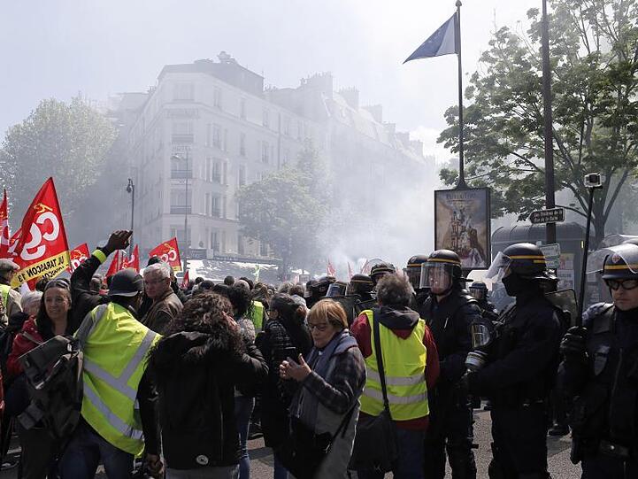Demonstranten marschieren durch Paris. Die "Gelbwesten" demonstrieren seit November gegen die Reformpolitik Macrons und der Mitte-Regierung.