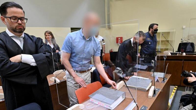 Der Angeklagte (Zweiter von links) steht beim Beginn des Prozesses zwischen seinen Anwälten. (Archivbild)