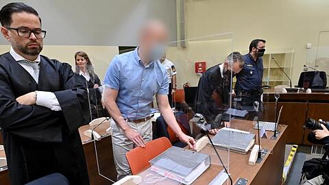 Der Angeklagte (Zweiter von links) steht beim Beginn des Prozesses zwischen seinen Anwälten. (Archivbild)