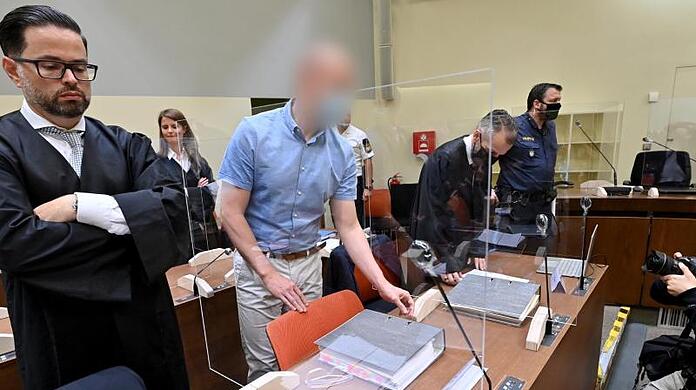 Der Angeklagte (Zweiter von links) steht beim Beginn des Prozesses zwischen seinen Anwälten. (Archivbild)
