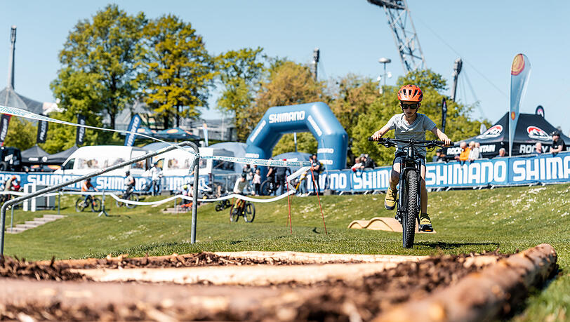 Ein Kind flitzt mit dem E-Mountainbike über holprigen Boden. Ein Kind flitzt mit dem E-Mountainbike über holprigen Boden.