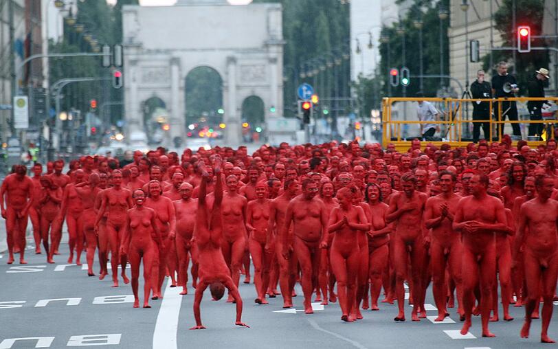 Star-Fotograf Spencer Tunick lässt zur Eröffnung der Opernfestspiele für seine Installation hunderte bunt angemalte Menschen durch München laufen. Das Highlight: Die rot-goldenen Teilnehmer stellen sich an Münchner Monumenten entlang der Ludwigstraße auf. Hier gibts die Bilder!