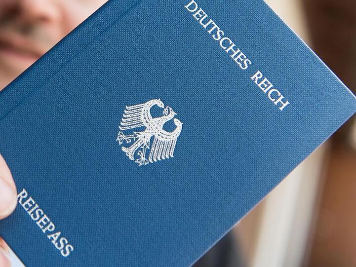 Ein Mann hält ein Heft mit dem Aufdruck "Deutsches Reich Reisepass" in der Hand. Foto: Patrick Seeger/Archivbild