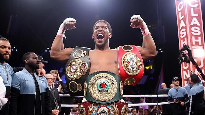 Anthony Joshua feiert seinen Sieg: Der Brite hat sich die Weltmeistergürtel der Verbände WBO, WBA, IBF und IBO umgehängt.
