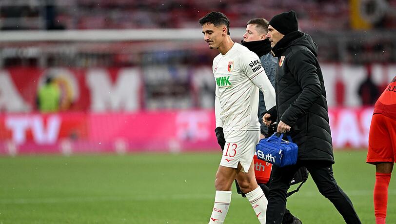 Augsburgs Verteidiger Dimitrios Giannoulis (l.) geht verletzt vom Platz.
