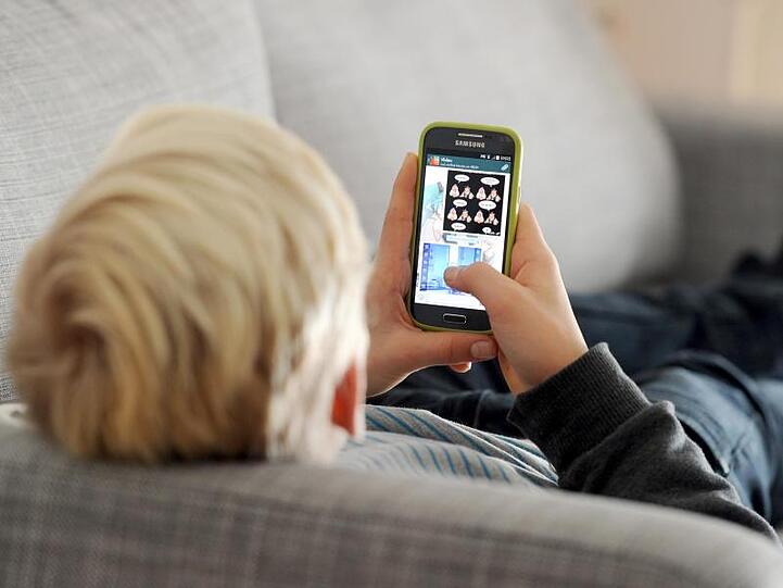 Keine Bücher, dafür täglich Hunderte von Kurznachrichten: ein Jugendlicher blickt auf sein Smartphone.