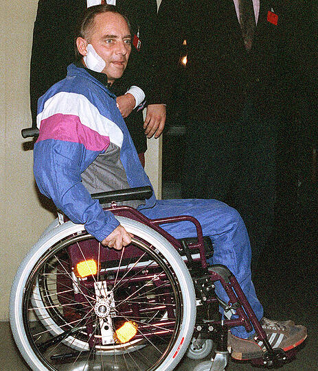 Wolfgang Schäuble (CDU) fährt knapp sechs Wochen nach dem Attentat in der Reha-Klinik Langensteinbach mit dem Rollstuhl zu einer Pressekonferenz. (Archivfoto vom 22.11.1990)