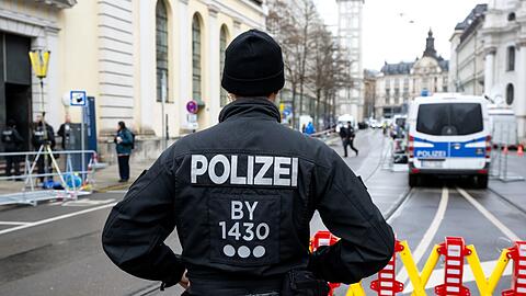Polizisten regeln vor Beginn der Sicherheitskonferenz 2023 die Zufahrt zum Hotel Bayerischer Hof.